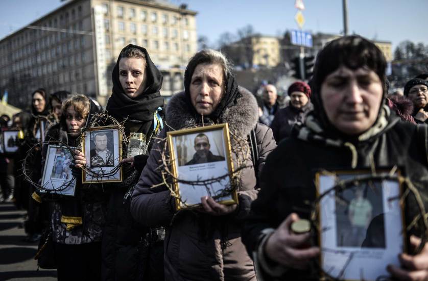 Women hold pictures of protesters who were killed in clashes with police during recent demonstrations as they take part in a commemerative procession in central Kiev on February 26, 2014. Ukraine's pro-Western interim leaders were set to unveil their new cabinet today after disbanding the feared riot police as they sought to build confidence in the splintered and economically ravaged ex-Soviet nation. AFP PHOTO/BULENT KILIC        (Photo credit should read BULENT KILIC/AFP/Getty Images)