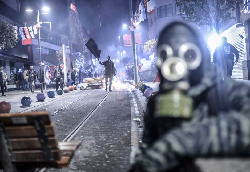 A protester waves a black flag during clashes with riot police in Kadikoy, on the Anatolian side of Istanbul, on March 11, 2014. Turkish riot police fired tear gas on March 11 at protesters massed outside a hospital after the death of a teenage boy wounded during anti-government protests last year and left comatose. Berkin Elvan, 15, who has been in a coma since June 2013 after being struck in the head by a gas canister during a police crackdown on protesters, died on March 11, his family announced via Twitter.  AFP PHOTO/BULENT KILIC        (Photo credit should read BULENT KILIC/AFP/Getty Images)