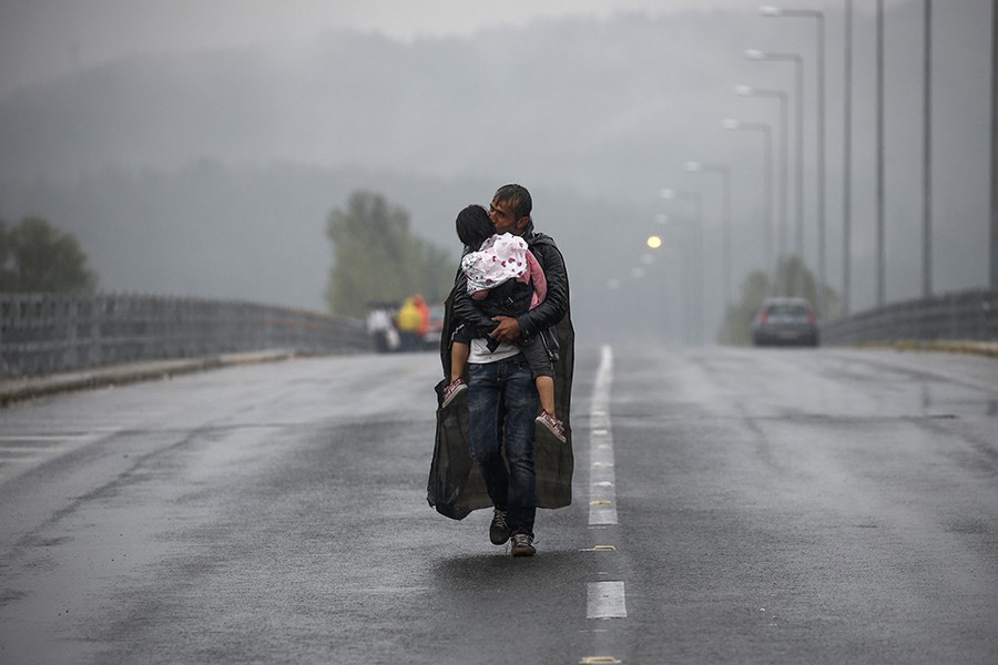 Syrian refugee kisses his daughter as he walks through a rainstorm towards Greece's border with Macedonia, near the Greek village of Idomeni / Yannis Behrakis, Thomson Reuters  - September 10, 2015