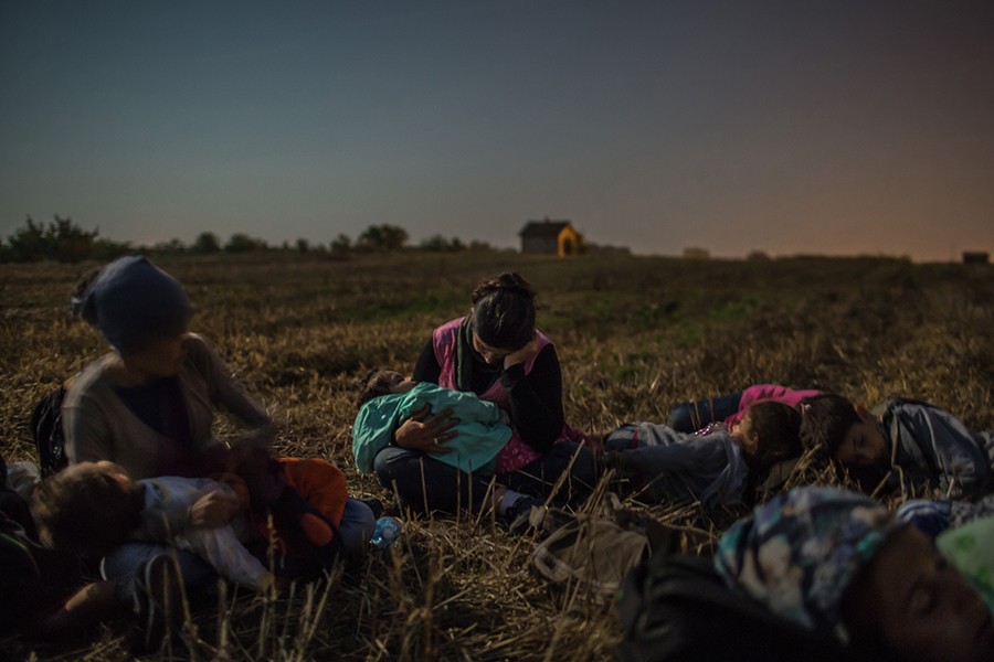 Members of the Majid family sleep with their children in their arms in a wheat field as they wait to cross the barbed wire fence at Horgos, Serbia, into Hungary / Mauricio Lima, The New York Times - August 31, 2015