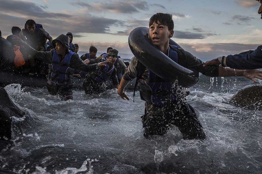 Migrants arrive by rubber raft on a jagged shoreline of the Greek island of Lesbos / Tyler Hicks, The New York Times - October 1, 2015