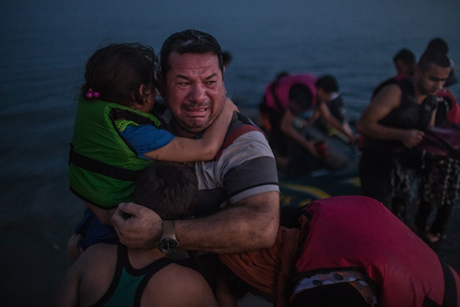 Laith Majid, an Iraqi, broke out in tears, holding his son and daughter after they arrived safely in Kos, Greece, on a flimsy rubber boat / Daniel Etter, The New York Times - August 15, 2015