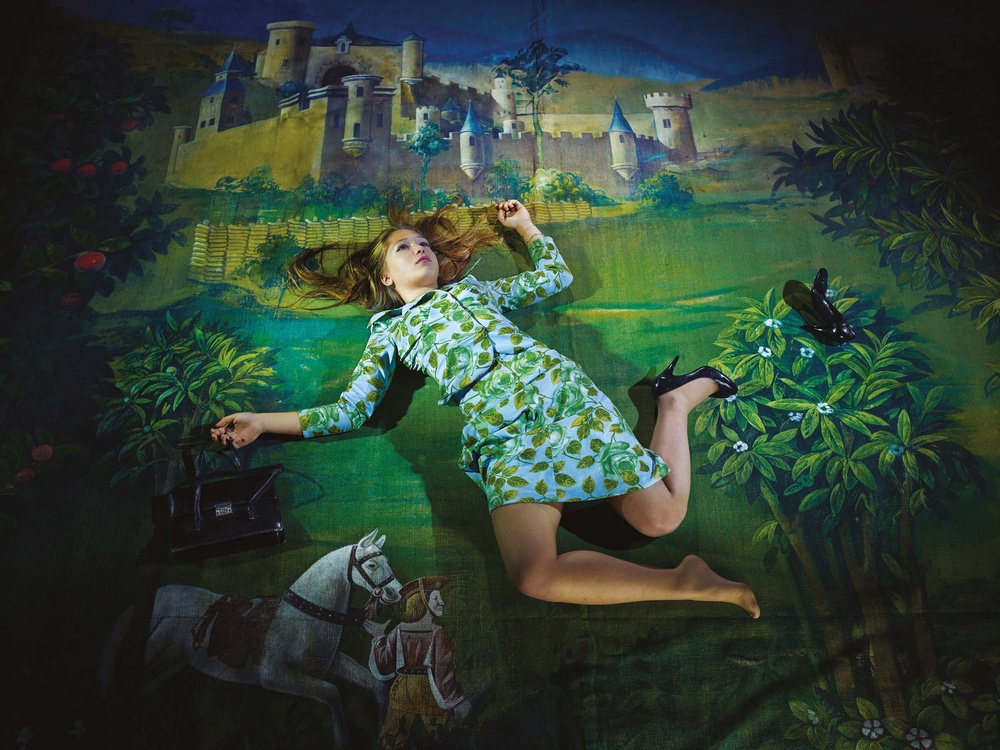 Una ragazza cade su un tappeto che rappresenta quello che la società introietta alle ragazze come desiderio: il principe azzurro, il castello … 