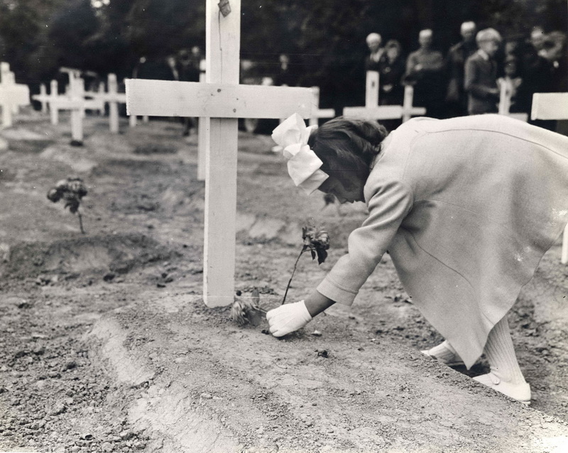 “Little girl putting flower on grave. The girl is French; the grave is American”. 14 July, 1944 Sainte-Mère-Église, France Photographer: unknown or not provided Courtesy Rodger Hamilton Collection / Photos Normandie / U.S. Army / U.S. National Archives