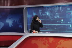 Sonia Niazaï, conduttrice dell'emittente televisiva privata Tolo News, si aggiusta il velo tra due notiziari. Le donne sono ora obbligate a coprirsi il viso quando escono e quando appaiono sullo schermo. Il governo ha ordinato agli uomini di far rispettare questa regola all'interno delle loro famiglie, pena sanzioni. Kabul, 26 maggio 2022. © Sandra Calligaro