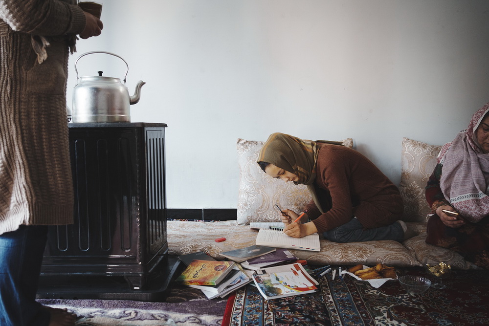 Fahima, 17 anni, studia nel salotto di casa. Sta seguendo un corso online a cui può accedere tramite il suo smartphone. Kabul, 24 gennaio 2025. © Sandra Calligaro