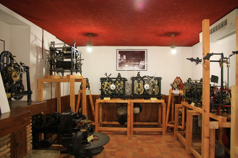 Questo è l'interno del Museo dell'Orologeria Pesarina, situato nel borgo di Pesariis (frazione di Prato Carnico, in Val Pesarina). Il museo custodisce una ricca e preziosa collezione di oltre un centinaio di pezzi tra orologi da torre, meccanismi da campanile, ingranaggi storici, pendoli e orologi domestici di varie epoche (dalle ricostruzioni di modelli del XV secolo fino ai più complessi sistemi industriali e civili). L'esposizione documenta anche l'ingegno e la maestria delle storiche famiglie artigiane della valle che fin dal XVII secolo resero celebre Pesariis come il "Paese degli Orologi". Il museo si affianca al celebre percorso all'aperto nel paese, che conta quindici grandi installazioni e orologi monumentali.