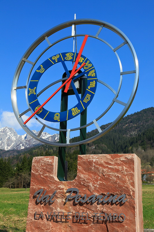Questo è il Calendario Perpetuo Gigante, uno delle quindici opere che compongono il percorso espositivo all'aperto di Pesariis (in Val Pesarina, il "Paese degli Orologi"). L'orologio è installato su un imponente blocco in pietra rossastra su cui campeggia la scritta "Val Pesarina - La valle del tempo". Il quadrante e lo zodiaco: la struttura circolare in metallo e il disco centrale blu evidenziano la fascia con i simboli dello zodiaco dipinti in giallo, permettendo di seguire la posizione del sole e il trascorrere delle stagioni in relazione alle montagne circostanti. Questo grande e complesso quadrante è progettato per indicare non solo l'ora e il giorno, ma anche i mesi, la durata del giorno e della notte e il calendario perpetuo.